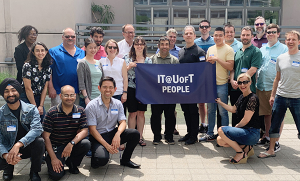 EASI’s Digital Workplace team holding "IT@UofT People" banner outdoors