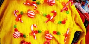 A yellow ugly sweater with candies as decorations.