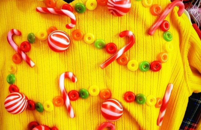 A yellow sweater with candies as decorations.