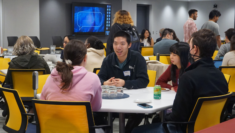 Student discussing at a round table during a event.
