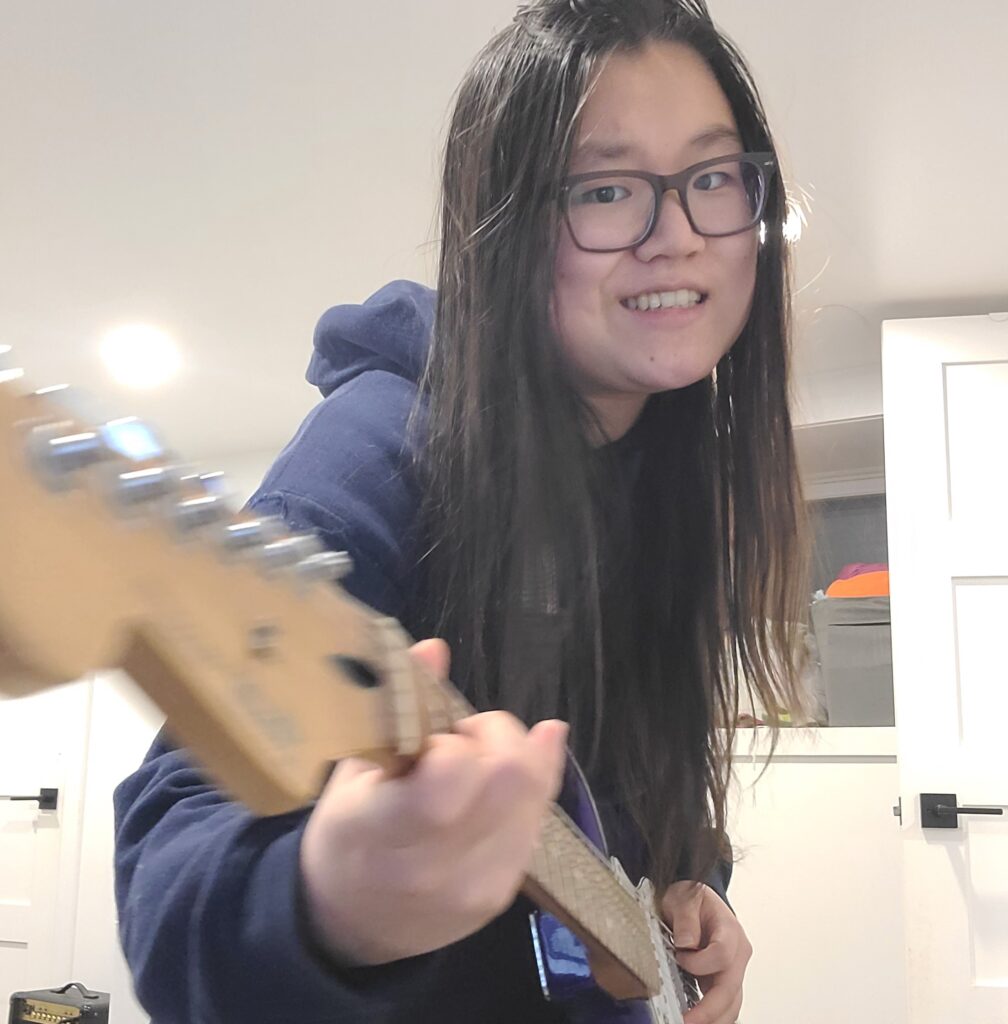 Stephanie Yang playing a guitar