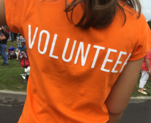 The back of a person's t-shirt with the word "Volunteer"