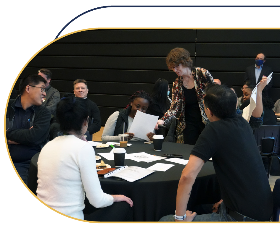 Laurie interacting with a group of staff during a working session.