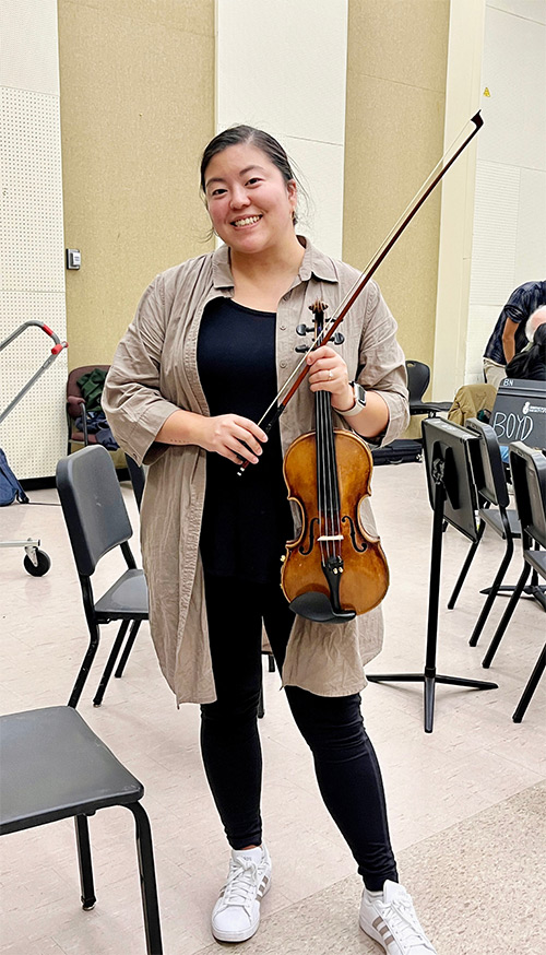 Photo of Jannie Chien holding a violin.