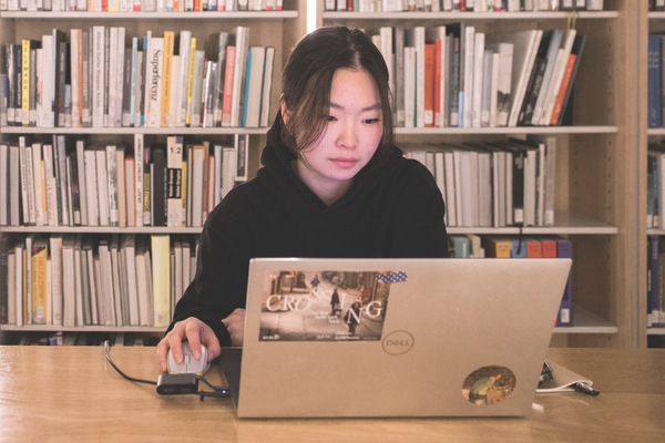 Student working on her computer in a library